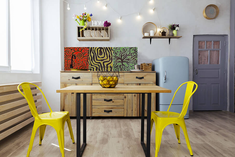 Un salon avec une table et un triptyque de dalles posé sur un meuble